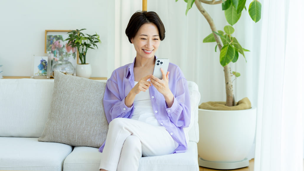 笑顔でスマートフォンを見る女性